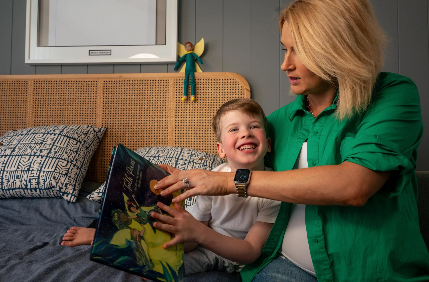 Woman and child reading a book together on a bed